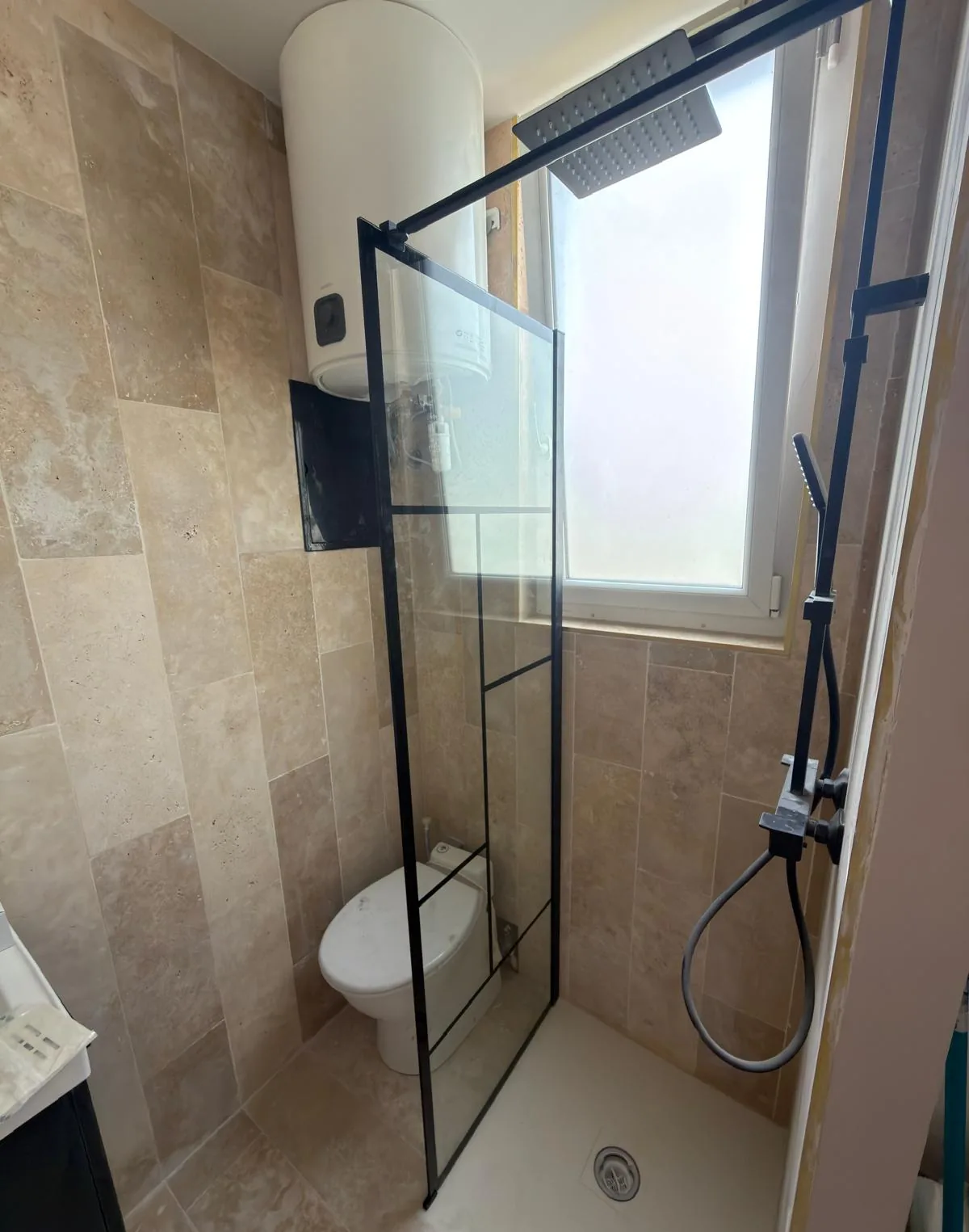 Paroi de douche à trame noire et colonne de douche encastrée