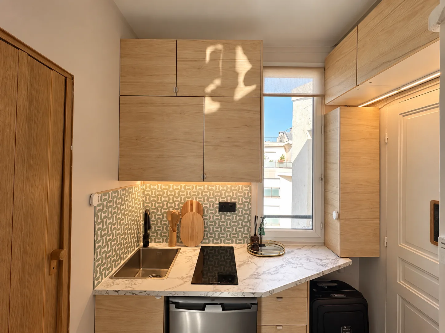 Kitchenette : façades bois, crédence à motifs et plan de travail en biais